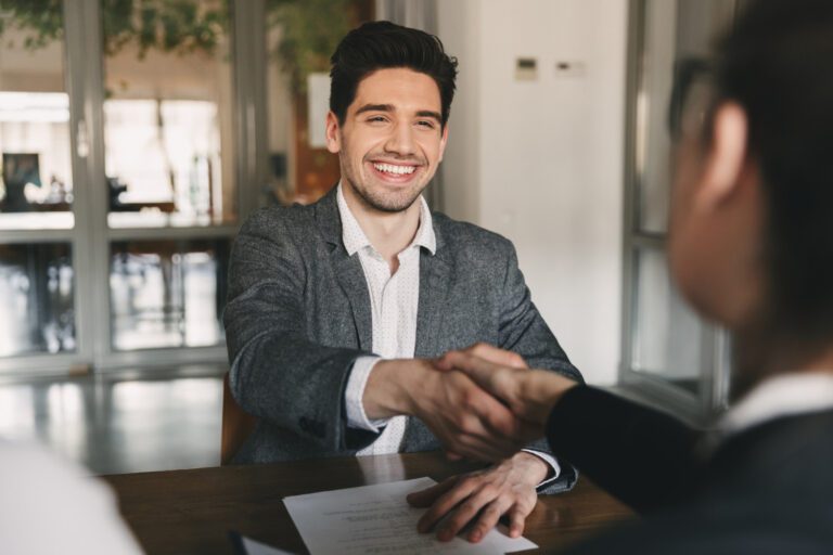 business career placement concept happy caucasian man 30s rejoicing shaking hands with employee when was recruited during interview office 768x512 1