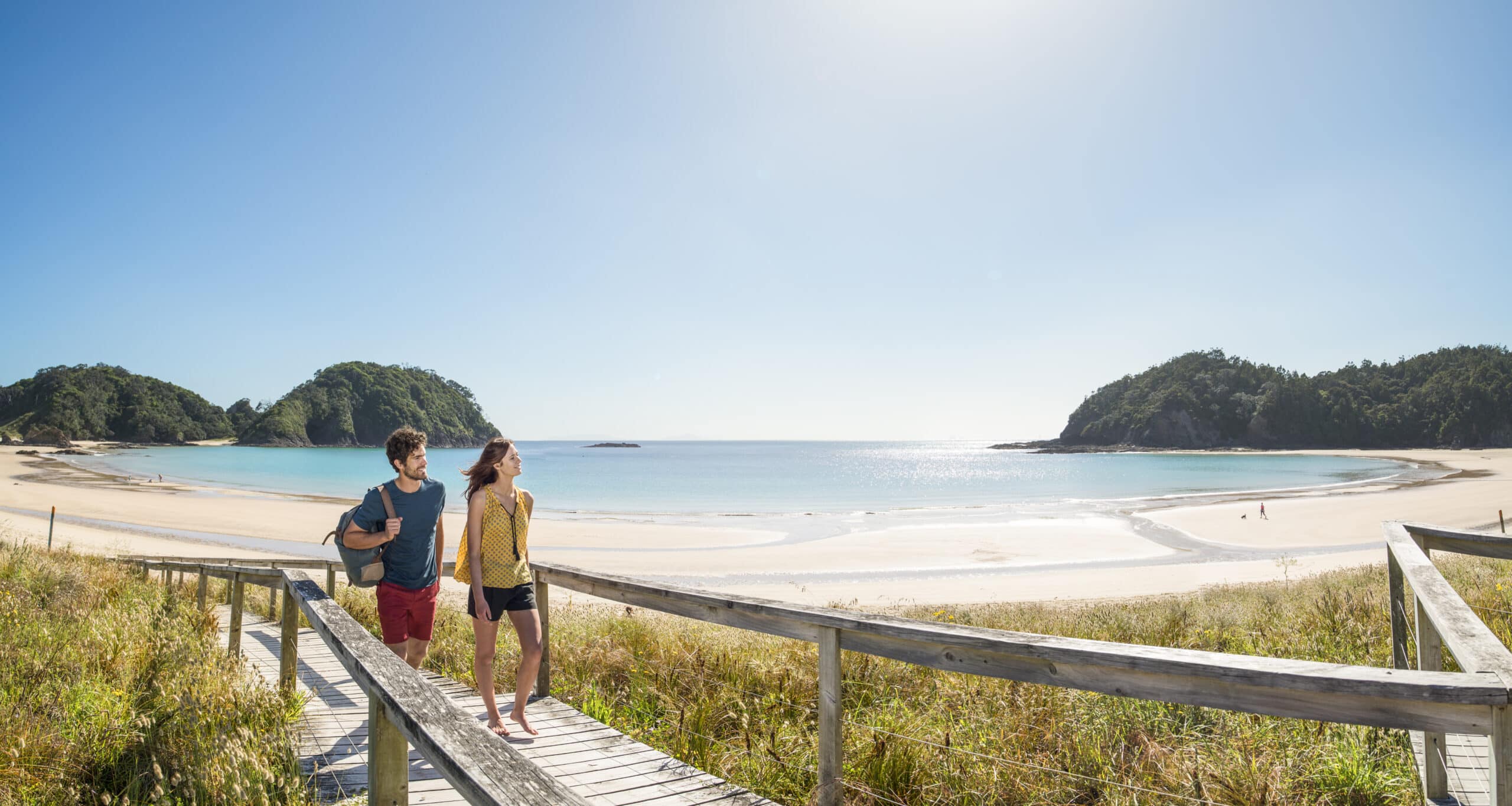 Two Permanent Resident Visa holders walking down the beach